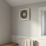 Ventilateur VMC très encrassé par la poussière et moisissures noires autour d'une fenêtre dans une pièce humide et mal ventilée.